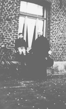 A Jewish child, Jacky Borzykowski, with the priest who placed him in hiding on a farm. Belgium, 1943.