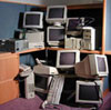 pile of computers, monitors, and keyboards