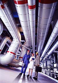 Photograph of three workers in an industrial facility.