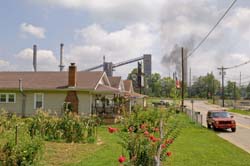 Photograph of a residential community with an industrial facility in the background