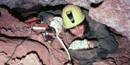 Caver surveying through a small passage in Wind Cave