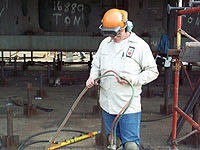 Fig 3. Burner with goggles inspecting hose
