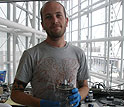 John Chmiola displays an electrochemical capacitor test cell in a home-built dry box.