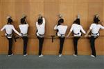 Students stretch against a wall during physical practice for Yueju opera at an art school in Hangzhou, Zhejiang province March 16, 2009. REUTERS/Steven Shi