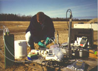 A technician is pumping water from a multi-level well during an investigation of the natural attenuation of a chlorinated solvent plume under a fire training pit at the former Wurtsmith Air Force Base, Oscoda, MI. Tubing from the well leads to an in-line multi-parameter probe that records pH, dissolved oxygen, Eh, and temperature