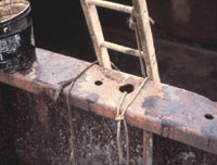 Hand line near portable wood ladder for raising and lowering tools, etc. to allow hands free for climbing