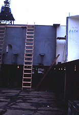 Portable wood ladder at proper angle (4 to 1 ratio) but not extending the required 3 feet above the landing
