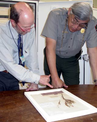 Uniformed NPS ranger and staff member from the Academy of Natural Sciences look at plant specimen collected by Meriwether Lewis.