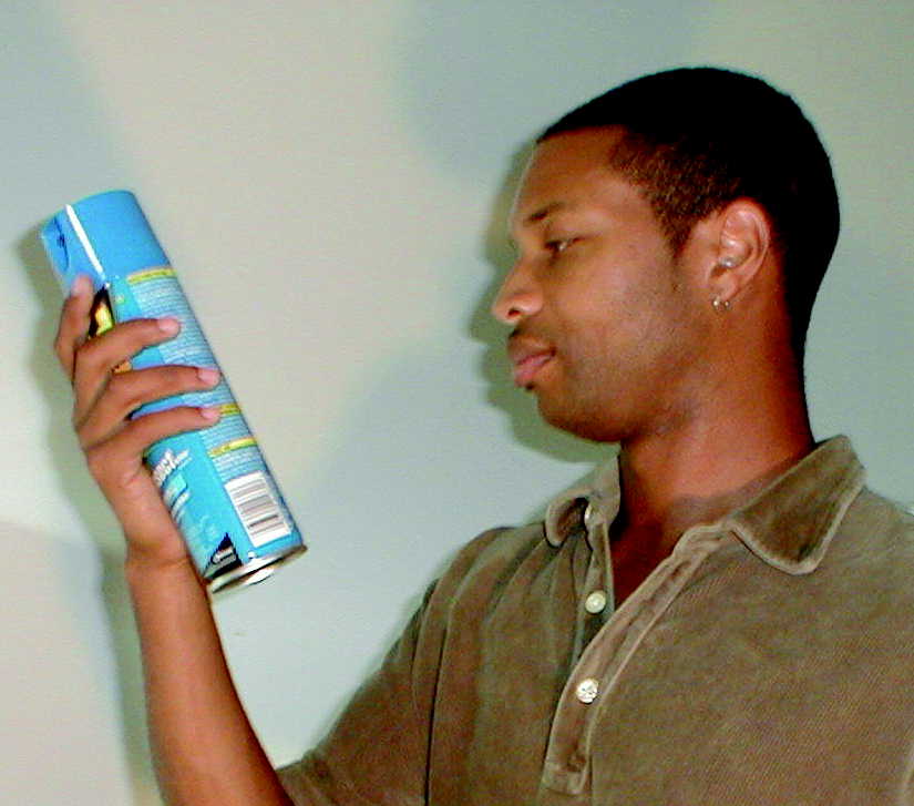 Man reading the label of a household aerosol product.