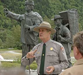 male ranger talks in front of statue of stampeders