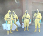 Scientists wearing protective gear for decontamination work.