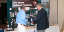 Two people look over Fire Island National Seashore display in lobby.