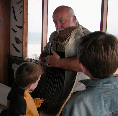 Ranger showing two boys how a whale's baleen works.
