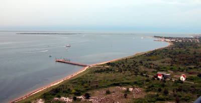 View of bayside dock and small community of Kismet as seen from atop the Fire Island Lighthouse, with a ribbon of sandy beach glowing from the pink sunset.