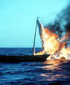 A picture of a Haitian saiboat on fire.