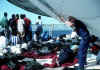 A picture of several Haitian migrants under a tent on a flight deck of a Coast Guard cutter.