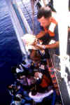 A picture of a baby being lifted aboard a Coast Guard Cutter.