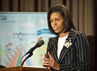 photo of First Lady Michelle Obama speaking to USDA employees with a MyPyramid for Preschoolers banner behind her