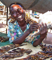 Esther Moriba and her family have benefitted from small business loans she received from a USAID program. She has been able to expand her fish-selling business