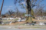 A plywood sign welcoming FEMA and insurance adjusters marks the debris-strewn lot where a home once stood on Second Street in Pass Christian, Miss.