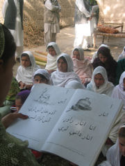Image of several girls holding a poster with writing on it. USAID/Afghanistan