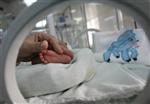 A doctor touches the feet of a premature baby lying in a toweling nest inside an incubator at the Neonatal Intensive Care unit at the Ramon Gonzalez Coro maternity hospital in Havana in this file photo from February 22, 2008. REUTERS/Claudia Daut