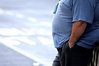 An overweight man stands at a bus stop in England in 2006. Men who were grossly overweight at the age of 18 had nearly 50 percent less chance of being married by their 30s and 40s, an international conference on obesity heard in Amsterdam on Thursday.(AFP/File/Paul Ellis)