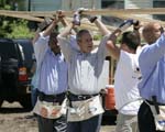 President George W. Bush helps volunteers from Operation Rebuilding Hands with the construction of a home in New Orleans, Louisiana, Thursday, April 27, 2006. Also pictured are Congressman Bill Jefferson, left, and New Orleans Mayor Ray Nagin.