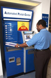 Image 6: A customer approaches an Automated Postal Center (APC) with Priority Mail package in hand.