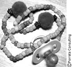 Une photo d'un collier de perles en plastique avec une tétine.