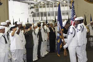 U.S. Navy Sailors salute the American flag while the National Anthem is sang during the U.S.S. George Washington Naturalization Ceremony.