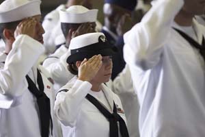 U.S. Navy Sailor salutes the American flag while the National Anthem is sang during the U.S.S. George Washington Naturalization Ceremony.