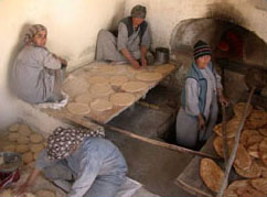 Photo: Afghan women prepare flatbreads at a bakery.