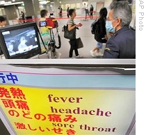 Quarantine officer monitors travelers with thermographic device at arrival gate in Narita International Airport, Japan, 27 Apr 2009