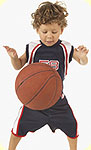 A boy dribbling with a basketball.