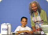 A grandmother baking with her grandson.