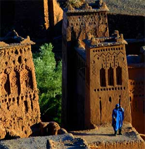 A man dressed in traditional Berber robe stands on top of the Ait Ben Haddou fortress near Ouarzazat, Morocco, December 31, 2002. [© AP Images]