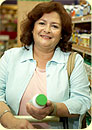 A woman holding a bottle of pills in a drugstore.