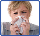 Photo of a man blowing his nose with a tissue