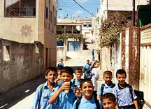 Photo of a group of boys posing for the camera in the alley of an urban setting.