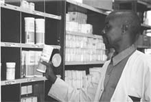 Photo of a South African health worker in a drug storage room.