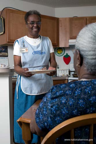 On April 1, 2008, Senior Companion Euphina Irvin eats breakfast with client Costella Black in her home in North Charleston, South Carolina.
