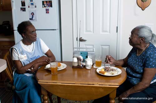 On April 1, 2008, Senior Companion Euphina Irvin eats breakfast with client Costella Black in her home in North Charleston, South Carolina.