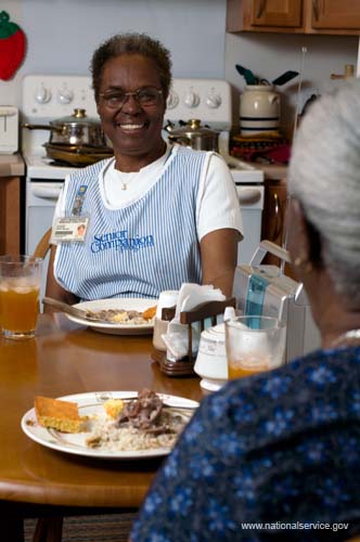 On April 1, 2008, Senior Companion Euphina Irvin eats breakfast with client Costella Black in her home in North Charleston, South Carolina.