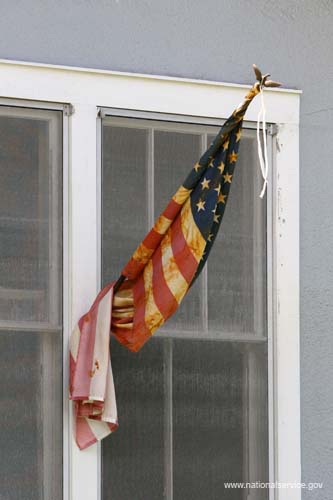 New Orleans, LA - An American flag hangs outside a house damaged by Hurricane Katrina in Lake View (New Orleans, LA).  More than 35,000 national service participants contributed more than 1.6 million hours of volunteer service during the first year of hurricane relief and recovery efforts along the Gulf Coast, according to a report released on August 25, 2006 by the Corporation for National and Community Service.