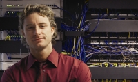 Man standing in front of servers and cables