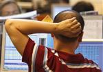 A trader scratches his head as he looks at his screens at a brokerage firm in Singapore October 10, 2008. REUTERS/Vivek Prakash