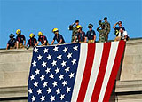 Firefighters draping an American flag off the roof of the Pentagon