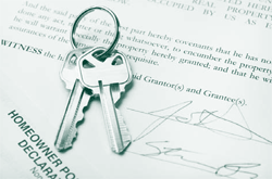 A picture of house keys lying on mortgage papers.