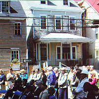 People sit in a closed Annapolis street, viewing a presentation 